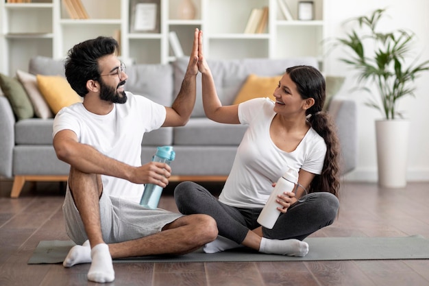 Pareja india chocando los cinco después de entrenar en casa