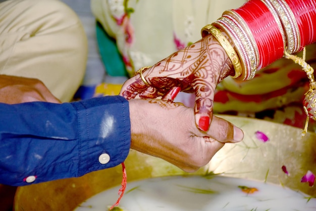 Pareja india jugando al juego de pesca con anillo en la ceremonia de la boda de la India