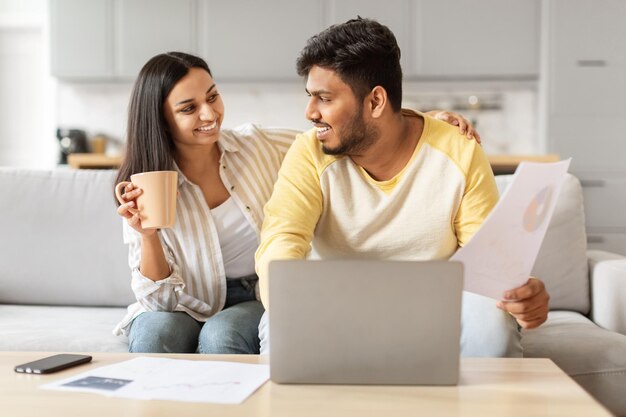 Foto una pareja india del milenio discutiendo finanzas en casa.