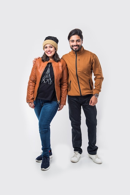 Pareja india en ropa de invierno o ropa de abrigo contra el fondo blanco.