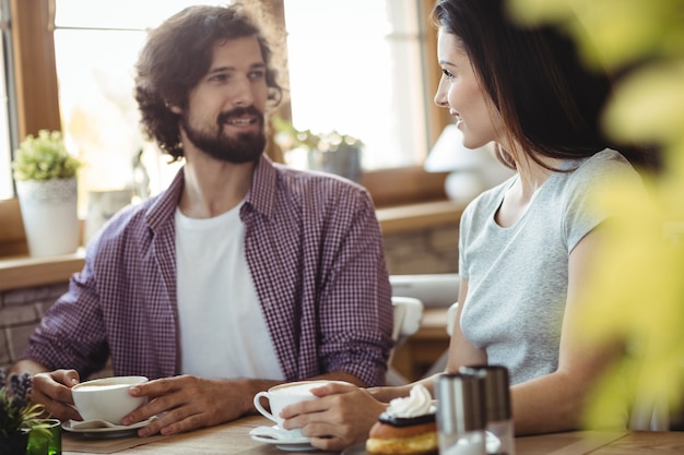 Pareja interactuando entre sí mientras toma un café