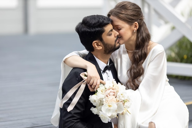 Pareja internacional besando al novio indio Sesión de fotos de boda en la calle