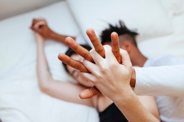 Pareja interracial cogidos de la mano en casa. Amor milenario entre dos razas diferentes.