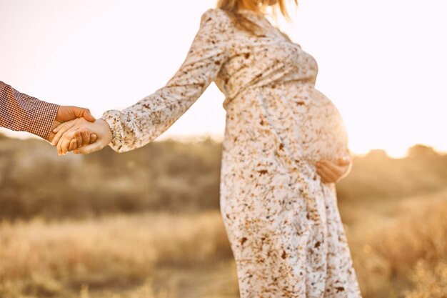 Pareja irreconocible futuros padres mujer joven embarazada tocando el vientre esperando un milagro Barriga embarazada de cerca al aire libre en el parque de primavera o verano