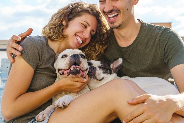 Foto una pareja irreconocible jugando con un perro en casa vista horizontal de una pareja riendo con bulldogs