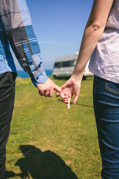 Pareja irreconocible tomados de la mano con dedos ganchudos