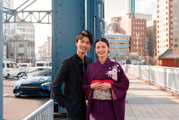 Foto pareja japonesa celebrando el día de la mayoría de edad y posando juntos en la ciudad