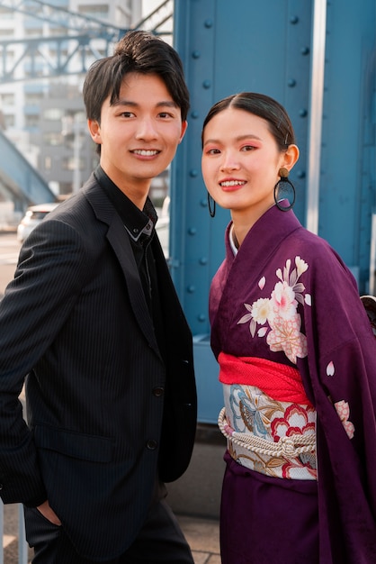 Foto pareja japonesa celebrando el día de la mayoría de edad y posando juntos en la ciudad