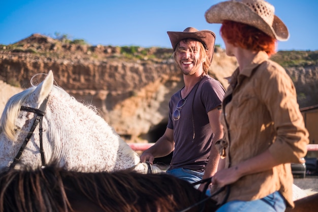 pareja de jinetes y caballos juntos en la carretera en las montañas. descubrir y viajar por el mundo con un estilo de vida alternativo. disfruta de la naturaleza y siente el silencio. escena del concepto de westerne