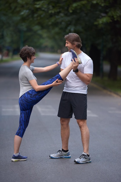 pareja de jogging calentando y estirando antes de correr