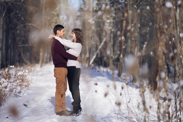 Pareja joven se abrazan en invierno en el parque. Historia de amor