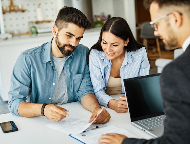 Foto pareja joven acuerdo contrato inversión inmobiliaria acuerdo de negocio agente documento firma reunión