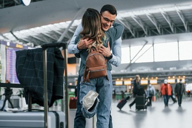 Foto una pareja joven está en el aeropuerto juntos.