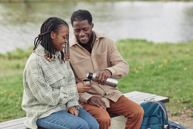 Pareja joven africana bebiendo té al aire libre