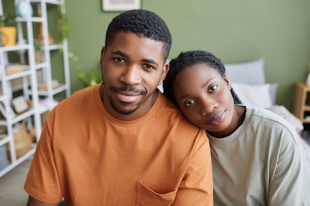 Pareja joven afroamericana sentada en el dormitorio