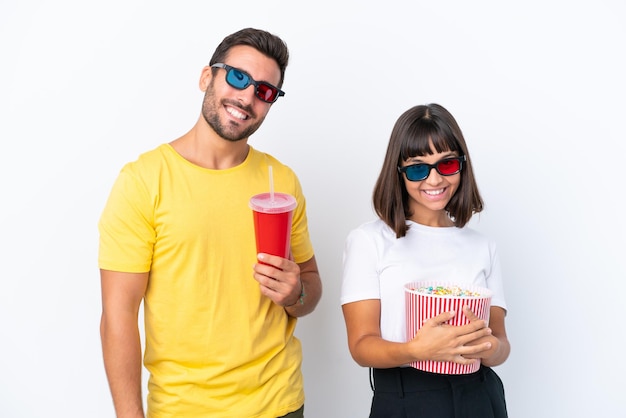 Pareja joven aislado sobre fondo blanco con gafas 3d y sosteniendo un gran cubo de palomitas de maíz