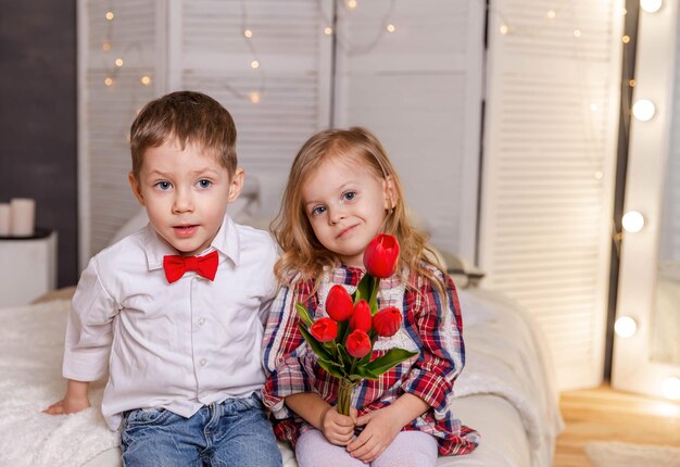 Pareja joven alegre abrazando a dulce niña y chico lindo tiene una cita