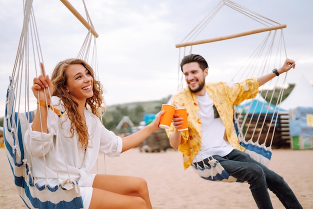 Pareja joven y alegre en un festival de música Gente bebiendo cerveza y divirtiéndose Fiesta juvenil