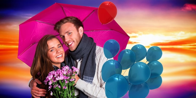 Foto pareja joven alegre con flores y paraguas contra el cielo púrpura con nubes naranjas