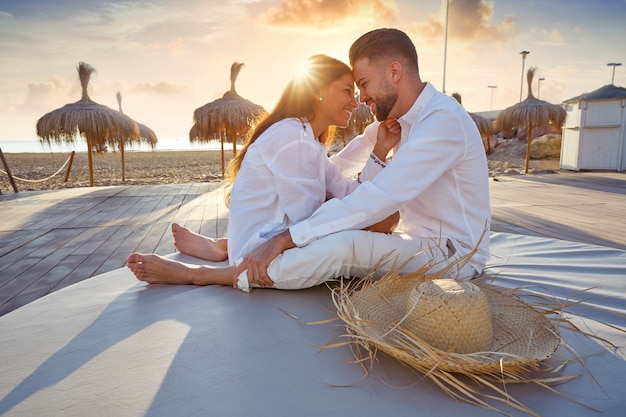 Foto pareja joven en el amanecer de vacaciones en la playa