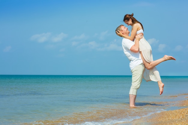 Pareja joven, ambulante, por el mar