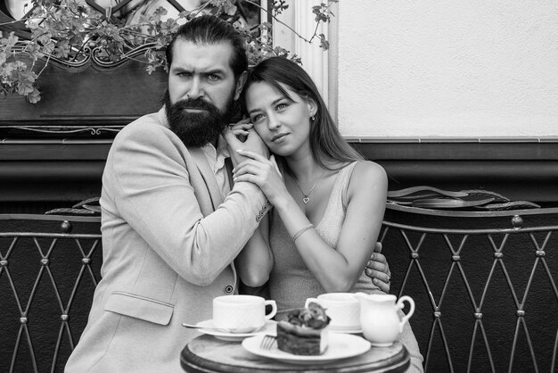 Una pareja joven y amorosa de moda se sienta en un café disfrutando de un café juntos por la mañana