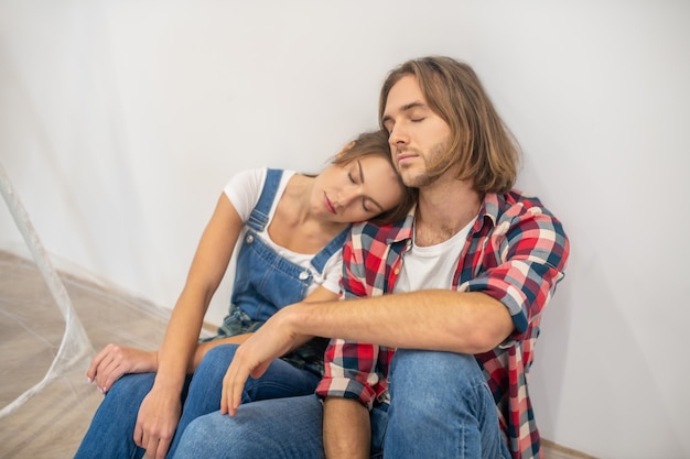 Pareja joven con aspecto cansado y descansando después del trabajo