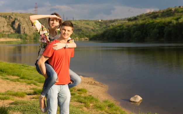 Pareja joven atractiva en un pintoresco lago de montaña