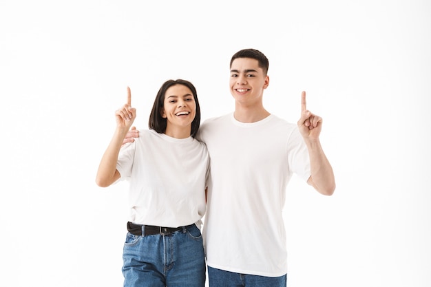 Foto pareja joven atractiva que se encuentran aisladas sobre la pared blanca