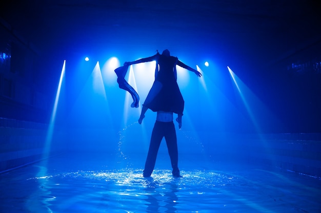 Pareja joven bailando en el agua.