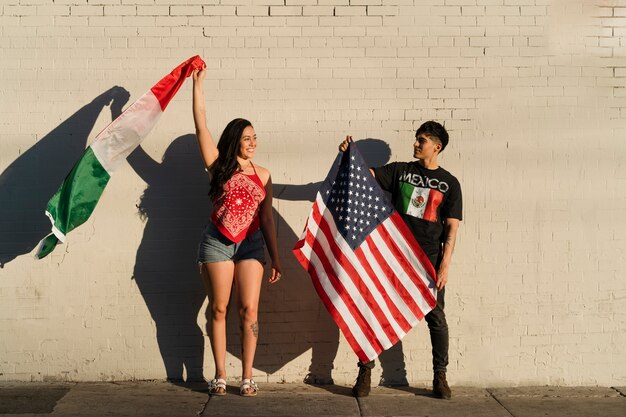 Pareja joven con banderas en la calle