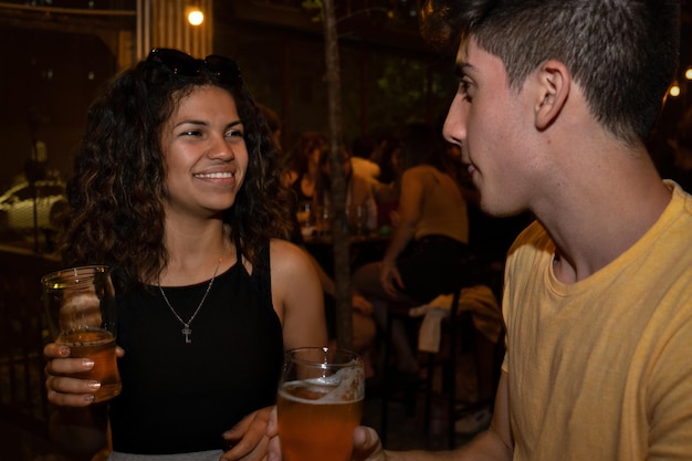 Pareja joven en un bar bebiendo cerveza. fondo borroso