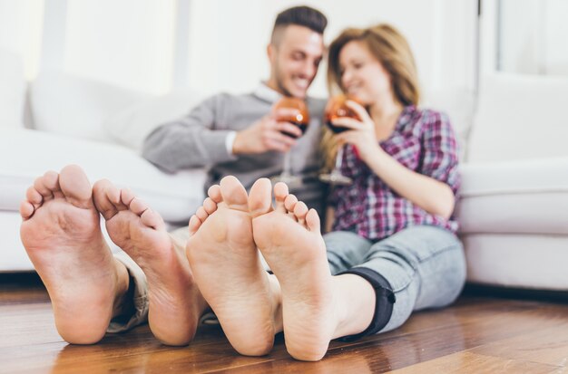 Pareja joven bebiendo vino en la sala de estar