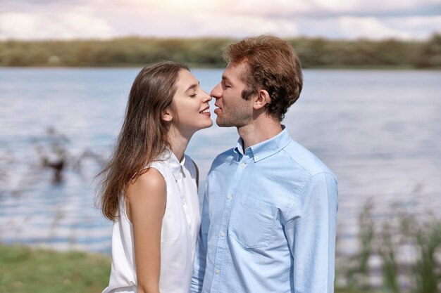 Una pareja joven se besa durante un paseo por el campo