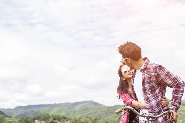 Foto una pareja joven besándose contra el cielo.