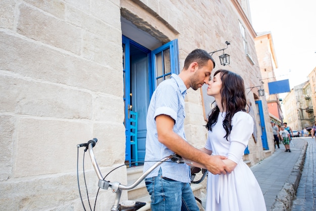 Pareja joven en bicicleta tándem en la calle de la ciudad