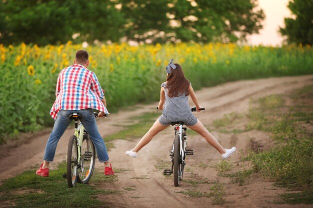 Foto pareja joven en bicicletas en el campo