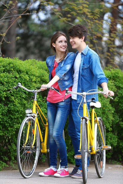 Foto pareja joven con bicicletas en el parque