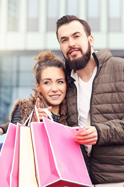 pareja joven, con, bolsas de compras, en la ciudad