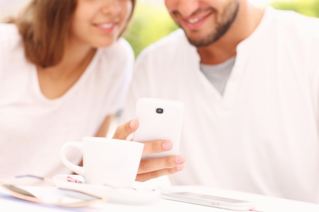 Foto una pareja joven borrosa y un teléfono inteligente