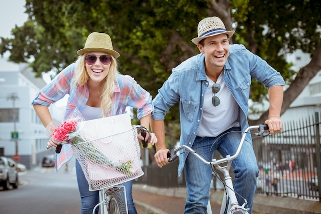 Pareja joven cadera va a dar un paseo en bicicleta