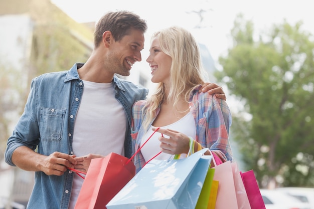 Pareja joven cadera sosteniendo bolsas de compras