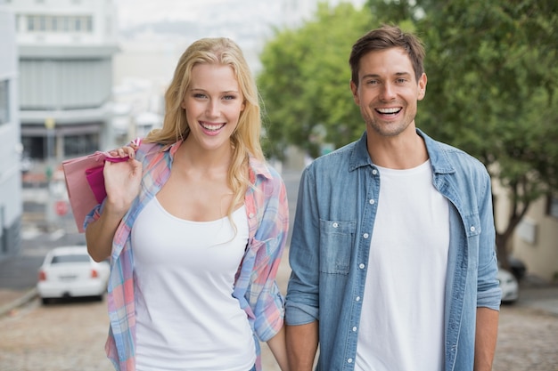 Pareja joven cadera en el viaje de compras caminando cuesta arriba