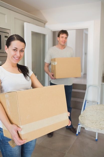 Foto pareja joven con cajas de mudanza