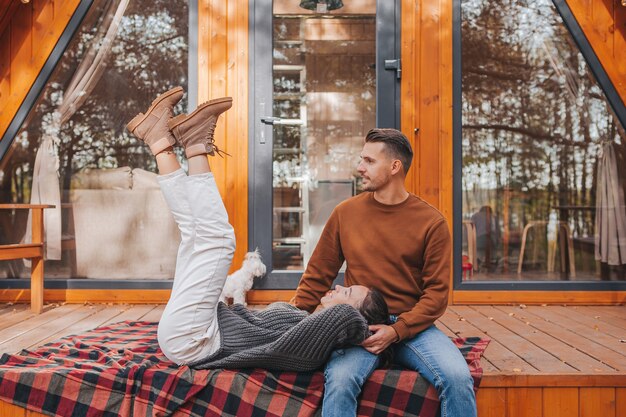 Foto pareja joven en un cálido día de otoño en la terraza de su casa