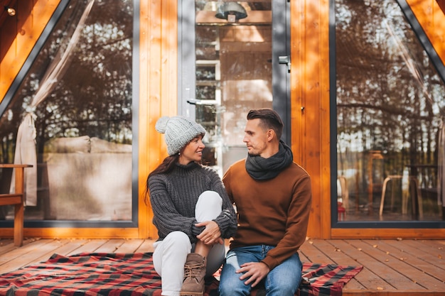 Pareja joven en un cálido día de otoño en la terraza de su casa