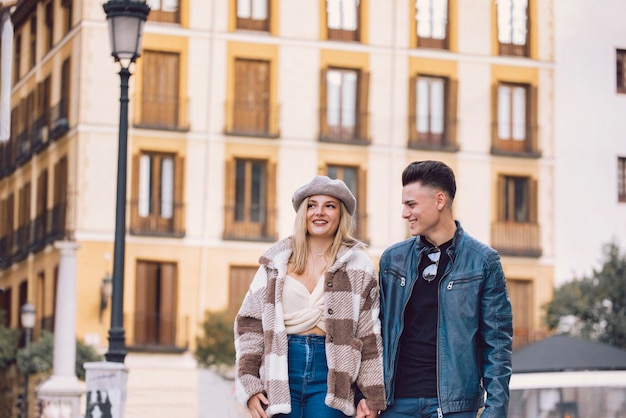 Foto pareja joven camina por la ciudad tomados de la mano