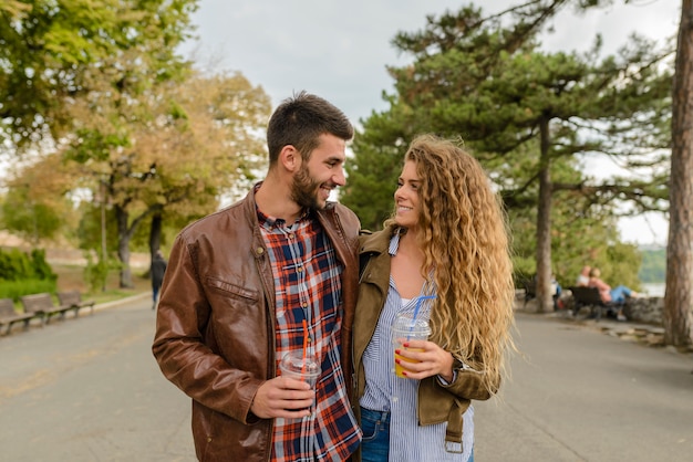 Pareja joven caminando en el parque de la ciudad