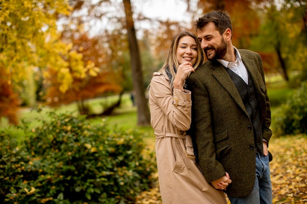 Pareja joven caminando en el parque otoño