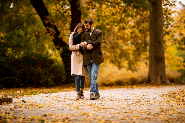 Pareja joven caminando en el parque otoño